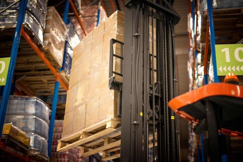 maquina-de-montacargas-industrial-que-levanta-la-paleta-llena-de-cajas-de-carton-y-las-coloca-en-estantes-en-las-instalaciones-del-almacen-de-distribucion